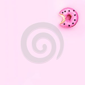 Freshly eaten donut isolated on pink background, top view and copy space