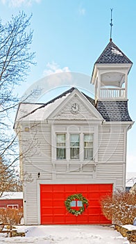 snow on old Stockbridge Firehouse with red overhead door decorated for Christmas photo