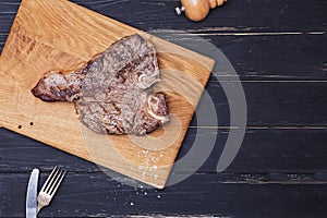 Freshly fried delicious meat T-bone steak on wooden board