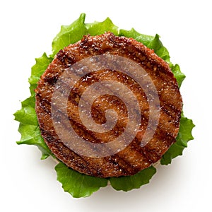 Freshly grilled plant based burger patty on bun with lettuce isolated on white. Top view