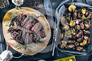Freshly grilled T bone steak with vegetables on wooden cuting board