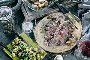 Freshly grilled T bone steak with vegetables on wooden cuting board