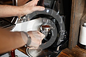 Freshly ground coffee beans in a portafilter by the coffee