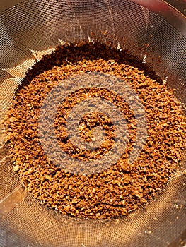 Freshly ground coffee in a metal brewing filter, close-up