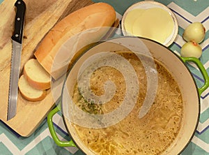 Freshly made French onion soup in a green pot