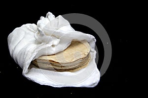 Freshly made and hot corn tortillas ready to eat and make Mexican tacos in a napkin to keep fresh