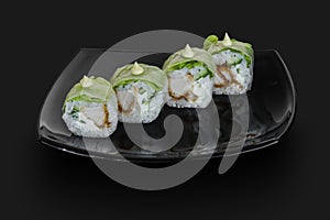 Freshly made Japanese sushi rolls served on a black stone slabDim