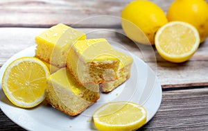 Freshly made lemon cake slices served with lemons