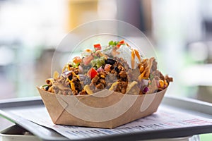 Freshly made nachos salsa on a tray in a paper plate at a street cafe