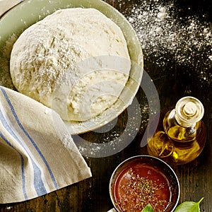 Freshly made pizza dough rising in a bowl