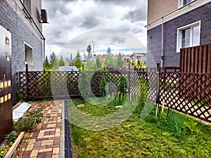 Freshly Mown Lawn in Residential Backyard on Overcast Day. Neatly trimmed grass behind a suburban home, bordered by a