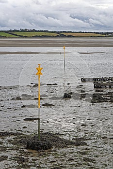 Freshly painted yellow Navigation Marks in the Estuary at low tide at St Kieran\'s Quay