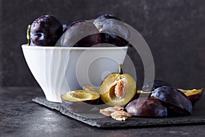 Freshly picked organic plums in bowl on table