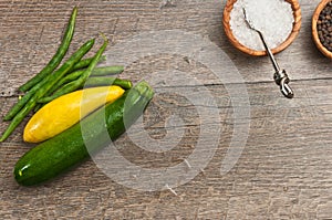 Freshly picked vegetables with wood bowls of sea salt and fresh pepper corns