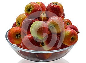 Freshly picked wild apples with water drops in a glass bowl
