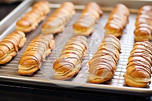 freshly piped eclair cases dry on a baking sheet