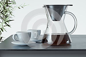 Freshly prepared black coffee in chemex pour over coffee maker near white coffee cup. Alternative brewing. 3d rendering