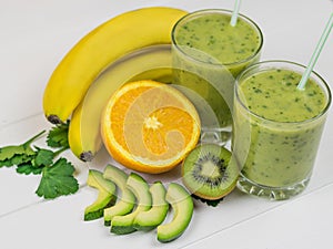 A freshly prepared smoothie of avocado, banana, parsley, lemon, orange and kiwi on a wooden rustic table. Diet vegetarian food. Ra