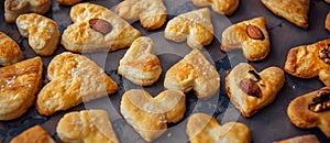 Freshly puff dough heart shaped cookies, top view close up. St Valentine`s Day concept. Abstract bakery background with copy space