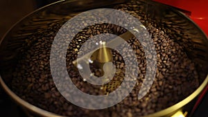 Freshly roasted aromatic coffee beans in a modern coffee roasting machine.
