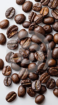 Freshly roasted coffee beans scattered on a white surface in a natural light setting