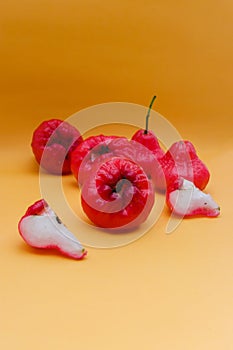 Freshly rose apple fruit isolated on orange background.