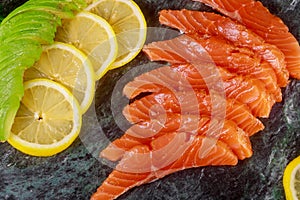 Freshly salmon sliced with avocado close-up on a plate