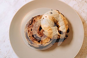 Freshly-sliced chocolate bagel is presented on a white plate