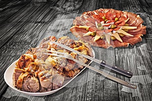 Freshly Spit Roasted Pork Meat and Savory Appetizer Dish Meze Served on Old Weathered Rustic Picnic Table Vignette Backdrop