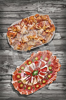 Freshly Spit Roasted Pork Meat and Traditional Garnished Appetizer Dish Served on Rustic Old Pinewood Table Vignette Backdrop