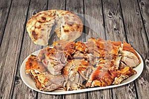 Freshly Spit Roasted Pork Shoulder Slices And Leavened Pitta Flatbread Torn Loaf Set On Old Pinewood Garden Table
