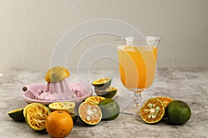 Freshly Squashed Orange Juice (Jeruk Peras in Indonesia) Serve on A Glass Above Brown Cement Table photo