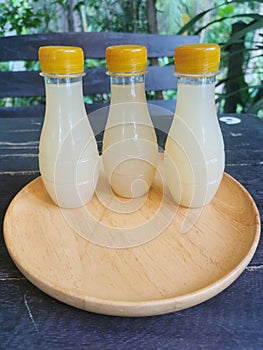 Freshly squeezed galingale juice in a plastic bottle placed on a brown wooden plate