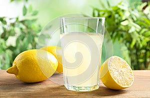 Fresco impreso limón jugo en vaso sobre el de madera mesa 