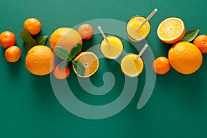 Freshly squeezed orange juice in a glasses and fresh fruits with leaves, healthy drink, vitamin c concept, overhead view, copy spa