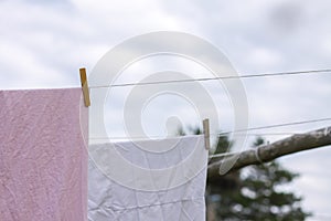 Freshly washed bed linen hanging on the rope outdoors