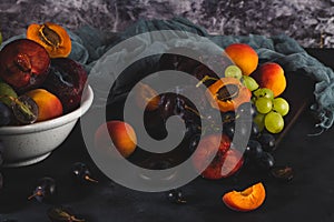 Freshly washed fruits with water droplets. bright high key look conveys freshness. Variety of fresh grapes, apricot and plumes on
