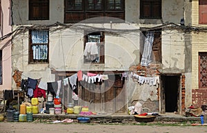 Freshly washed laundry is hung out to dry in front of a decaying house in Nepal.