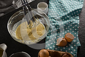 Freshly whisked batter of beaten eggs, milk and butter in a bowl photo