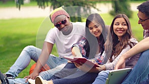 Freshmen reading book sitting outdoors. photo