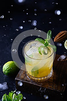 Freshness tropical lemonade with lime, orange and mint on black. Vertical format