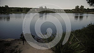 Freshwater angling with rods beside a lake.