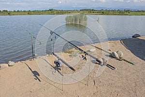 Freshwater angling with rods beside a lake. fishing rod on a prop and water background