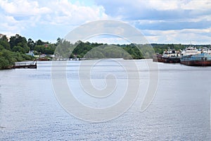 Freshwater bay with boats, rusty cargo ships