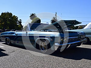 A blue and green colored 1965 Chevy Impala at car show in Ca. 2021