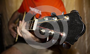 The fretboard of an old acoustic guitar