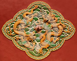 Fretwork in the form of a dragon on the red wall in the Forbidden City. Beijing