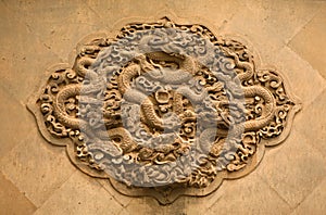 Fretwork in the form of a dragon on the wall in the Forbidden City. Beijing,