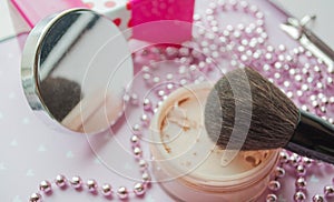 Friable powder and brush on the background of a mirror