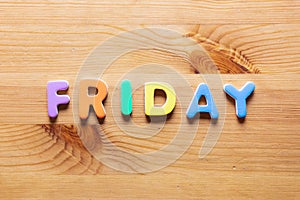 Friday word written with colorful letters on wooden table background